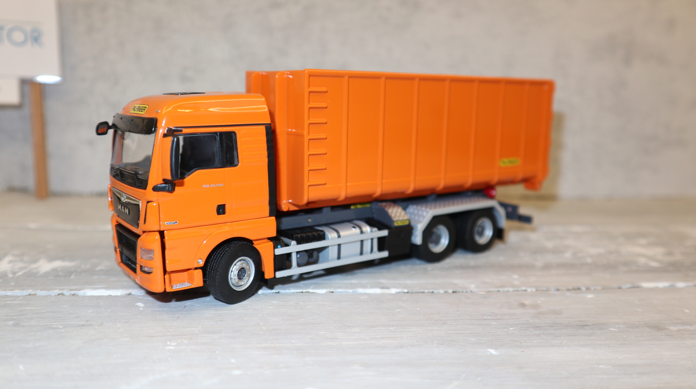 WSI 02-2195 in 1:50, MAN TGX 6x4  orange als Abroller mit 40cbm-Container, NEU in OVP